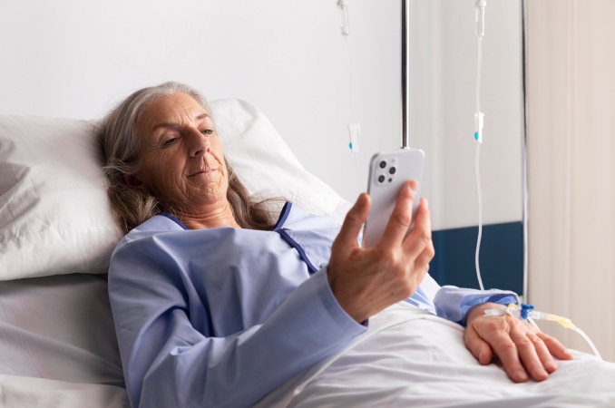 mujer mayor mirando el movil en la cama mujer mayor mirando el movil en la cama