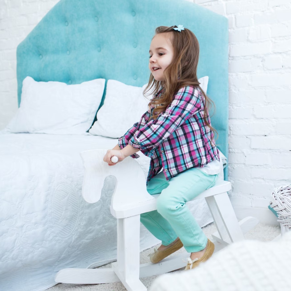 nina en un balancin al lado de la cama nina en un balancin al lado de la cama